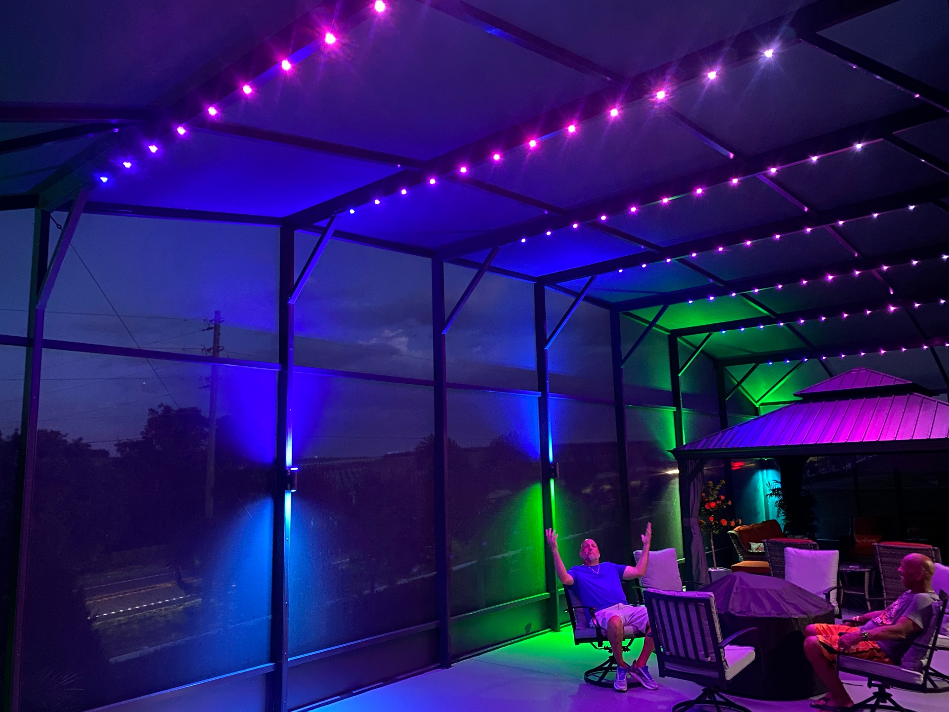 Florida pool cage lit with vibrant color-changing lights at night