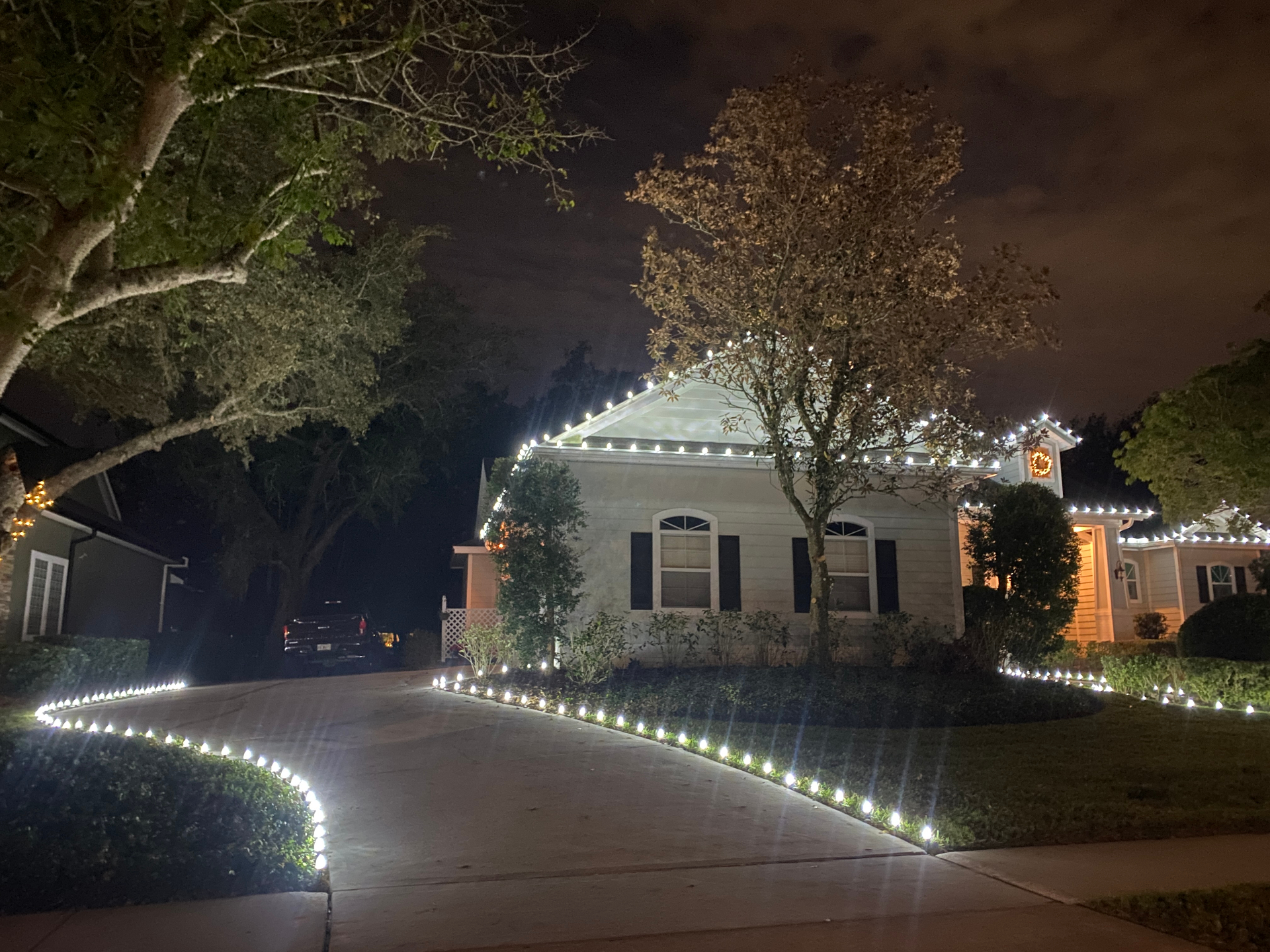 Home with crisp white roofline lights and pathway lights lining the curved driveway
