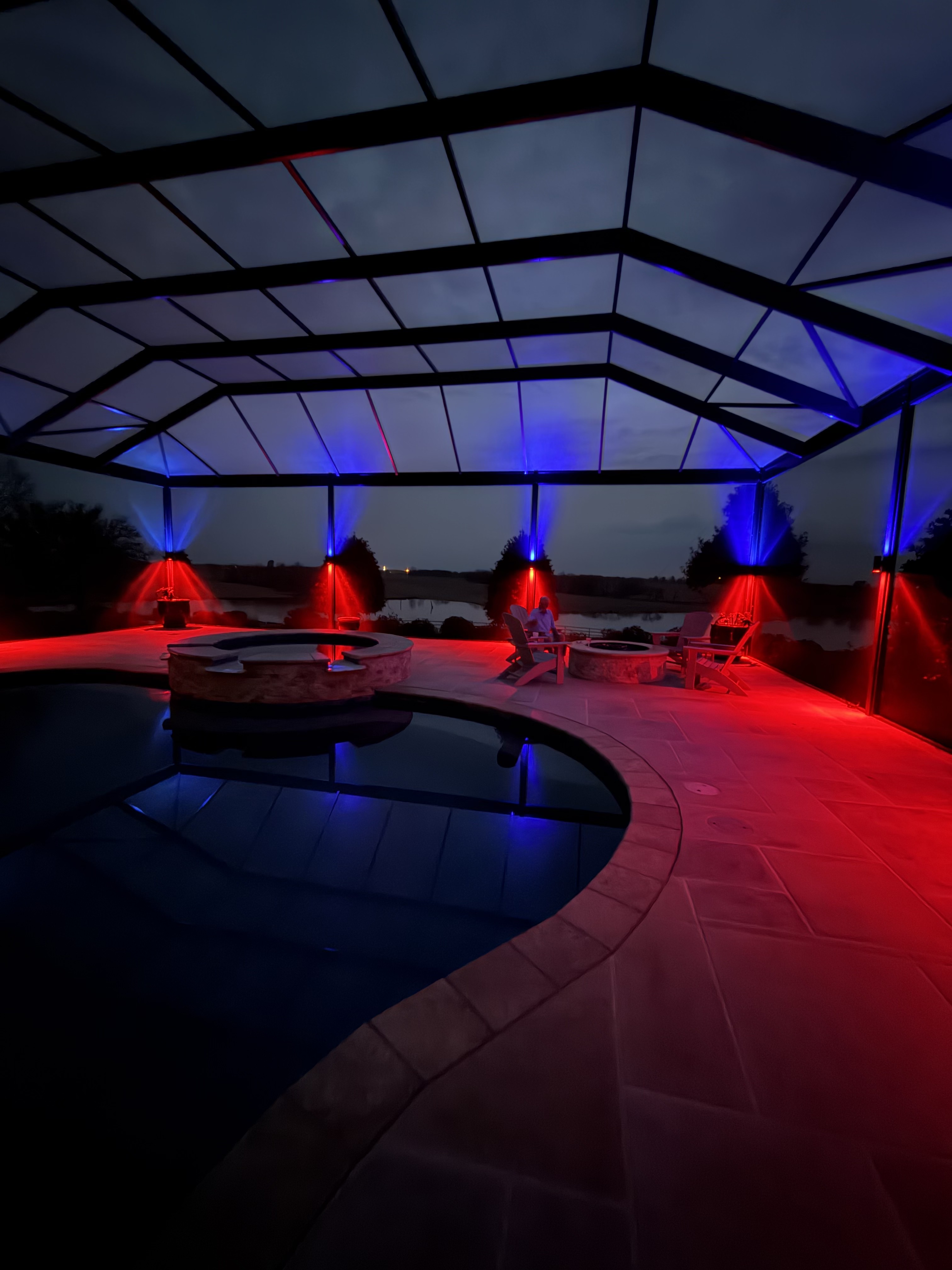 Pool deck lit in patriotic red and blue with color-changing permanent lighting