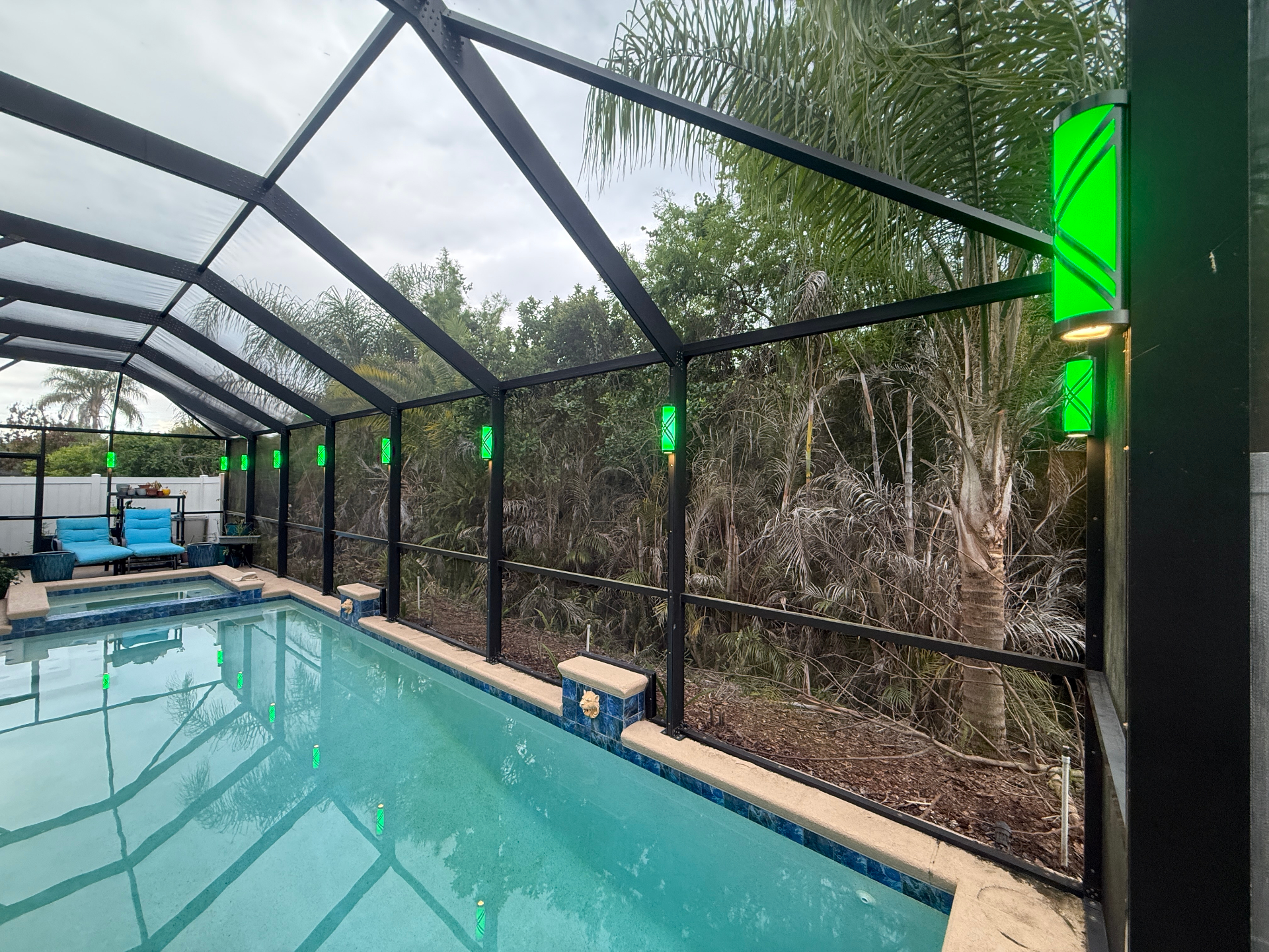 Pool enclosure with bright green permanent accent lighting on the cage frame